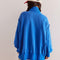 back view of model wearing cobalt blue oversized sweatshirt with snap henley front and slits on the cuffs