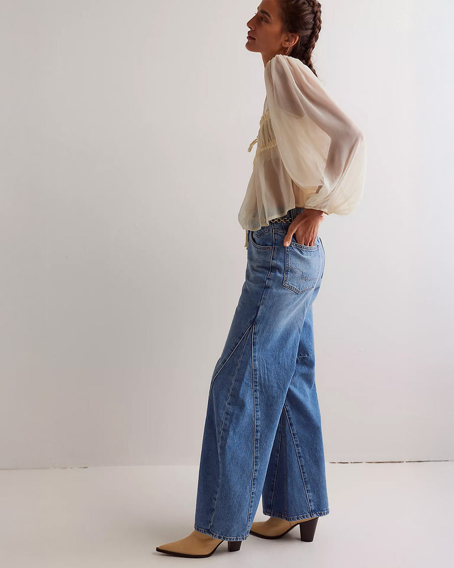 side view of model wearing medium washed denim with flared buttons