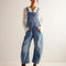 model wearing light denim barrel legged overalls