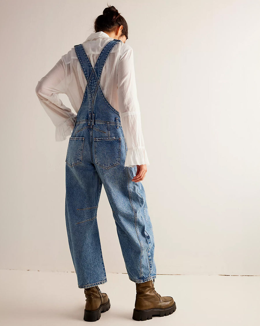 back view of model wearing light denim barrel legged overalls