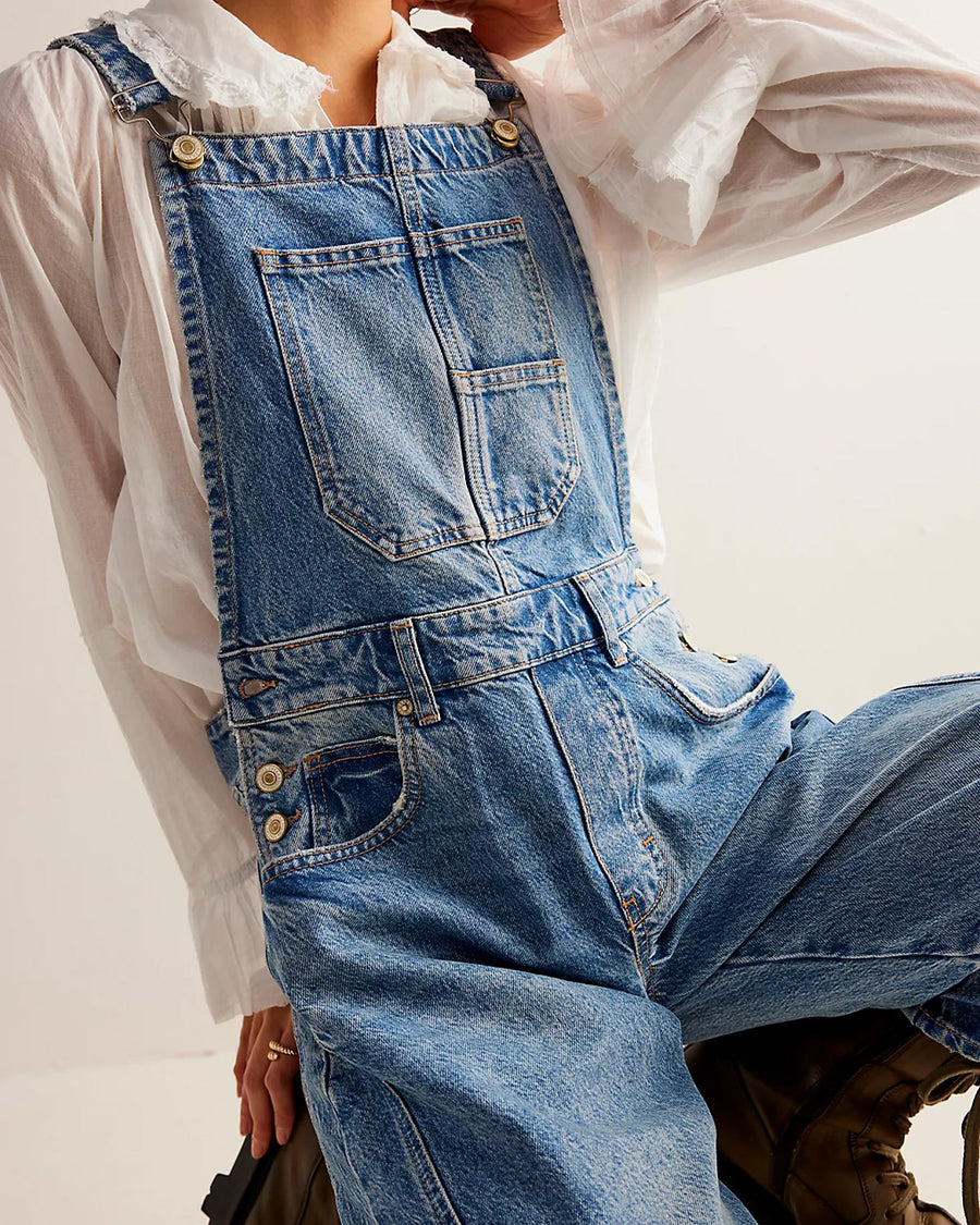 up close of model wearing light denim barrel legged overalls