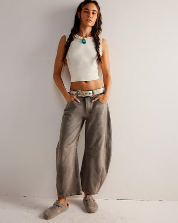 model wearing vintage washed grey barrel jeans with pleats at the knees