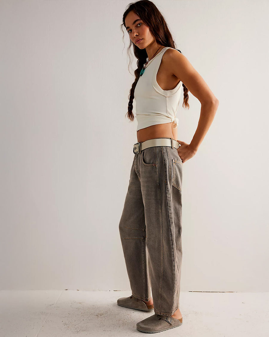 side view of model wearing vintage washed grey barrel jeans with pleats at the knees