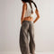 back view of model wearing vintage washed grey barrel jeans with pleats at the knees