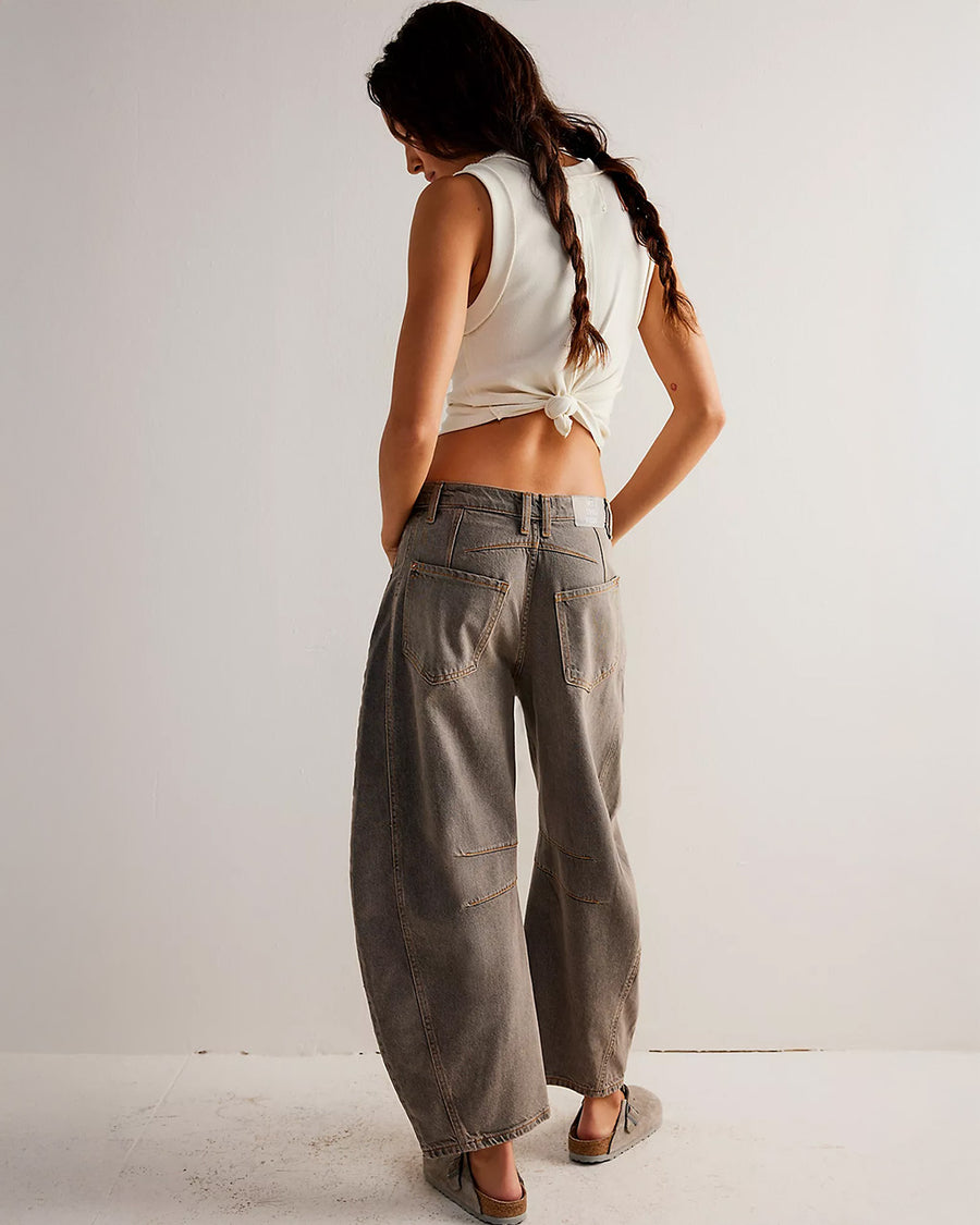 back view of model wearing vintage washed grey barrel jeans with pleats at the knees