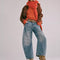 model wearing light denim wash barrel jeans with dart detail on the interior legs