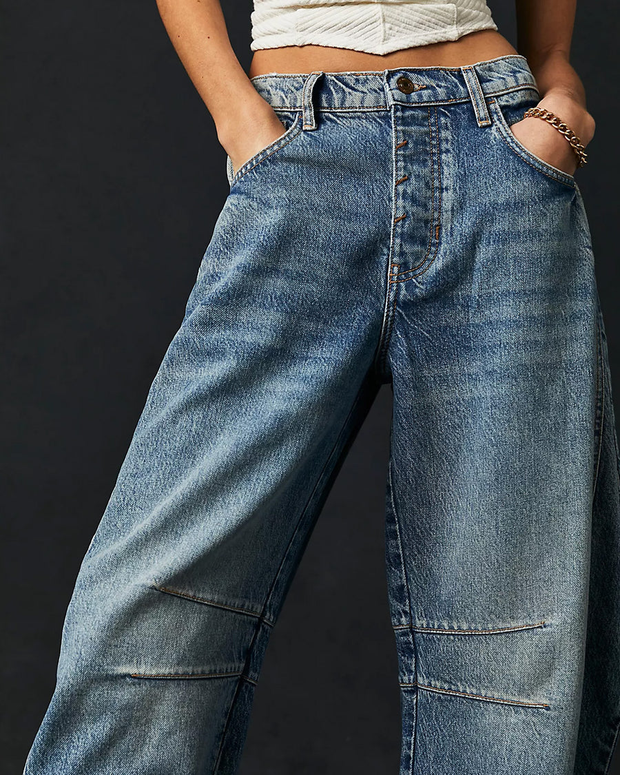 up close of model wearing light denim wash barrel jeans with dart detail on the interior legs