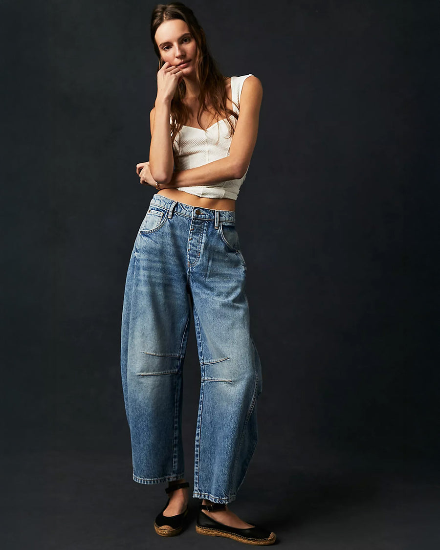 model wearing light denim wash barrel jeans with dart detail on the interior legs