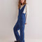 model wearing dark wash relaxed fit jumpsuit with front seaming and front patch pockets