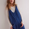 model wearing dark wash relaxed fit jumpsuit with front seaming and front patch pockets