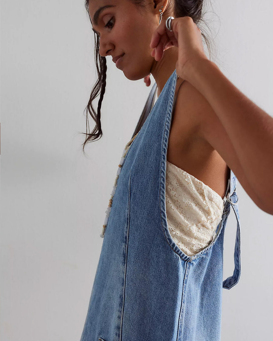 side view of model wearing light denim mini skirtall with front patch pockets