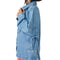 sideview of model wearing light denim oversized jacket with front patch pockets and button front