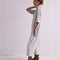 side view of model wearing light wash shapeless jumpsuit with button front and large front patch pockets