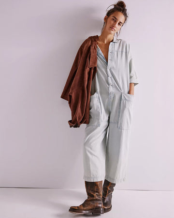 model wearing light wash shapeless jumpsuit with button front and large front patch pockets