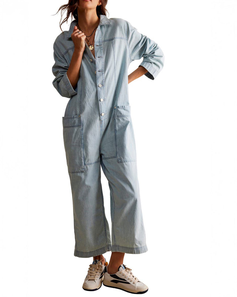 model wearing light wash shapeless jumpsuit with button front and large front patch pockets