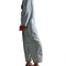 side view of model wearing light wash shapeless jumpsuit with button front and large front patch pockets