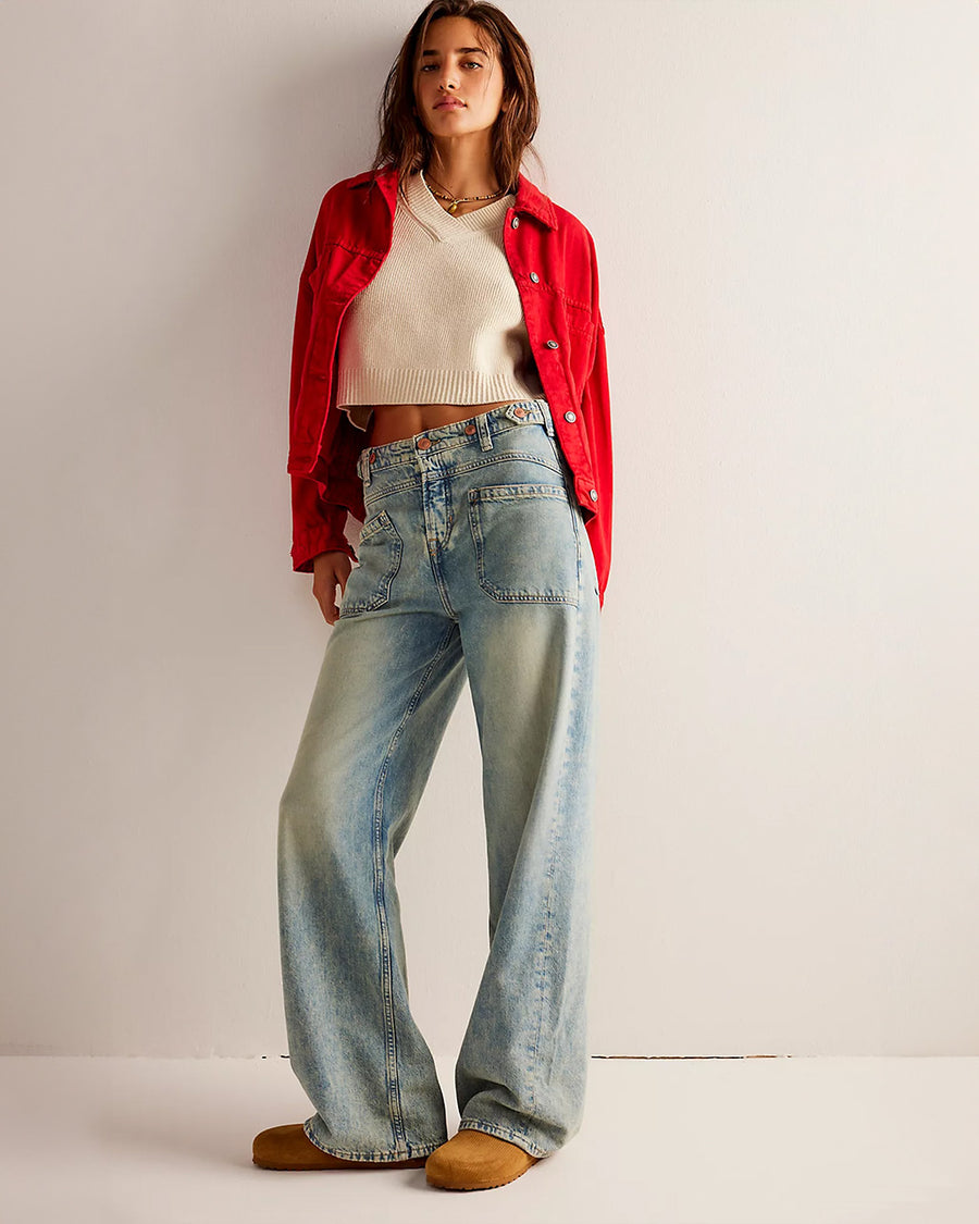 model wearing worn wash denim jeans with front sailor pockets and wide legs