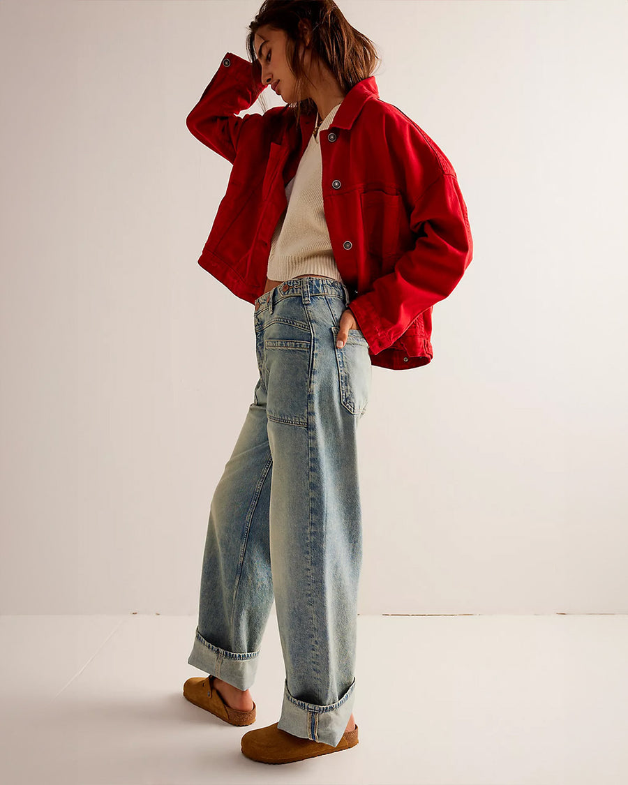 side view of model wearing worn wash denim jeans with front sailor pockets and wide legs