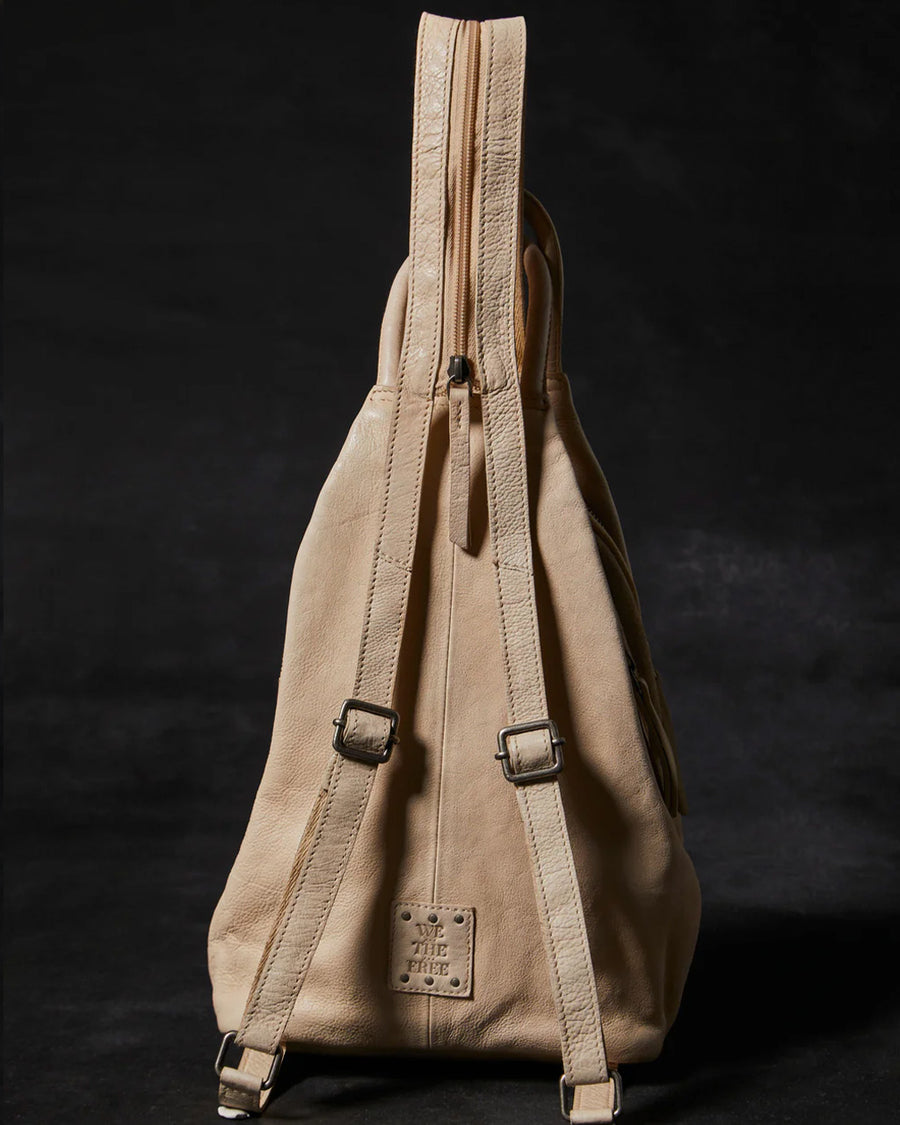 back view of champagne bag with various zippers and convertible straps