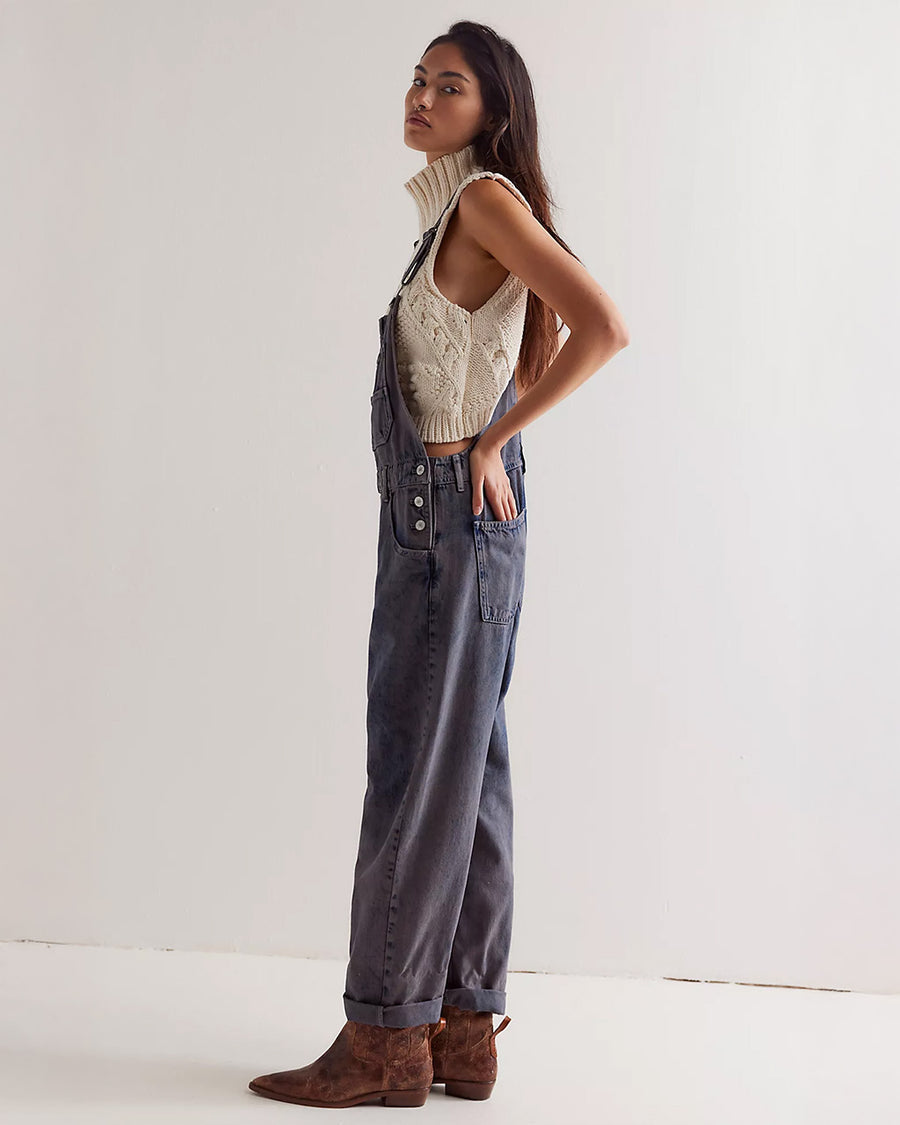 side view of model wearing washed black relaxed fit overalls