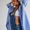 side view of model wearing medium blue overalls with front pockets, adjustable straps and side button openings