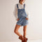 model wearing medium denim shortalls with front pockets, adjustable straps and front pouch pocket at the bust 