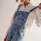 side view of model wearing medium denim shortalls with front pockets, adjustable straps and front pouch pocket at the bust 