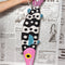 model holding black and white beaded fish shaped clutch bag with pink face and blue fins