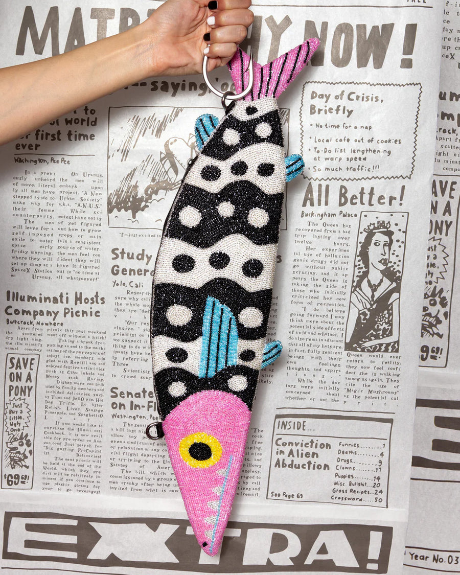 model holding black and white beaded fish shaped clutch bag with pink face and blue fins