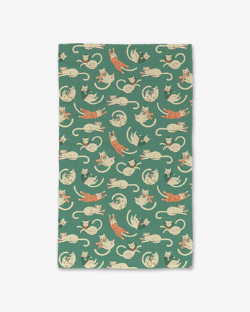 green teal towel with white cats in scarves, sweaters and christmas jammies