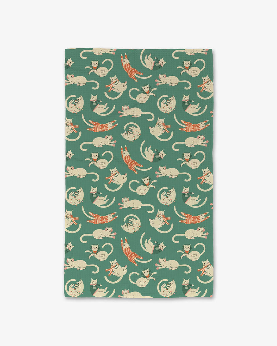 green teal towel with white cats in scarves, sweaters and christmas jammies