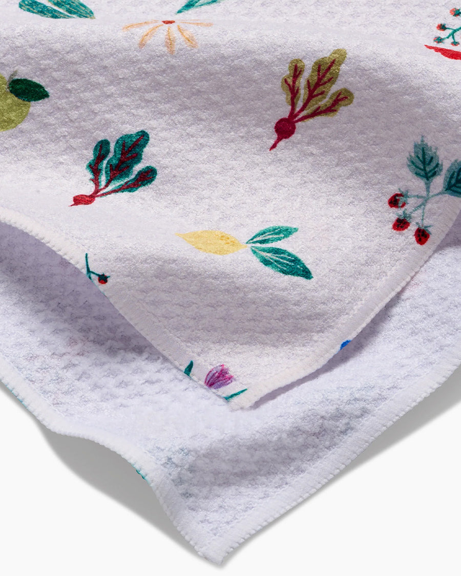 up close of white tea towel with all over veggie print