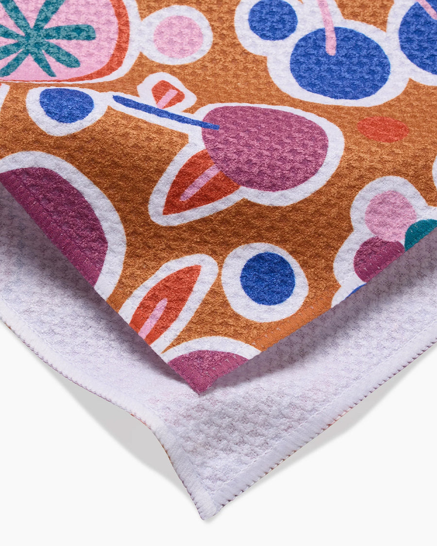 up close of burnt orange tea towel with abstract fruit print