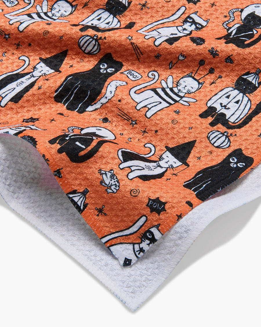 up close of orange tea towel with cats in costumes print