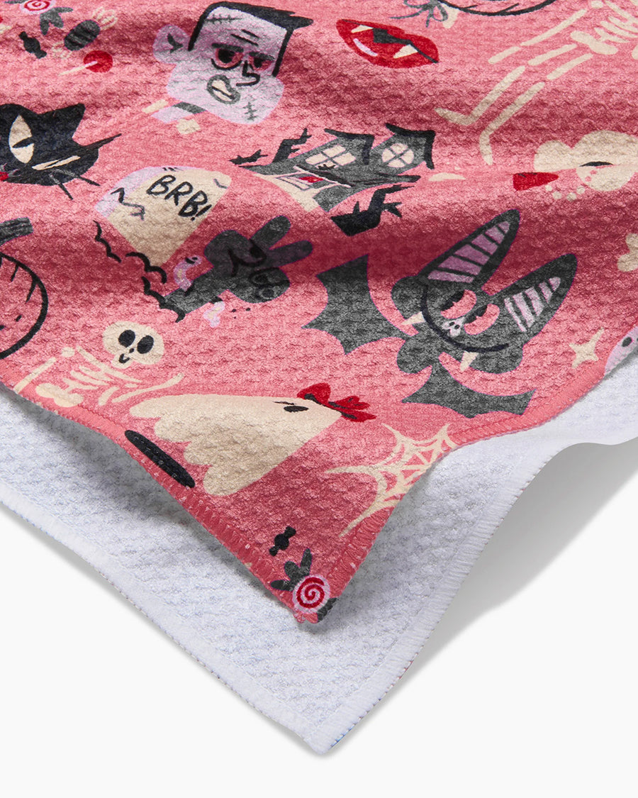 up close of pink tea towel with halloween print