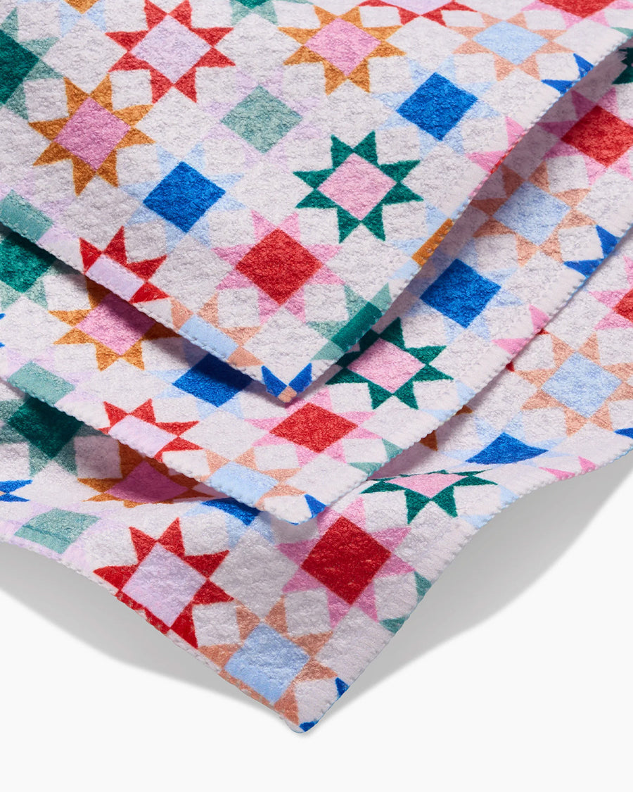 up close of set of 3 dish cloths with colorful patchwork print