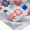 up close of white tea towel with colorful patchwork print