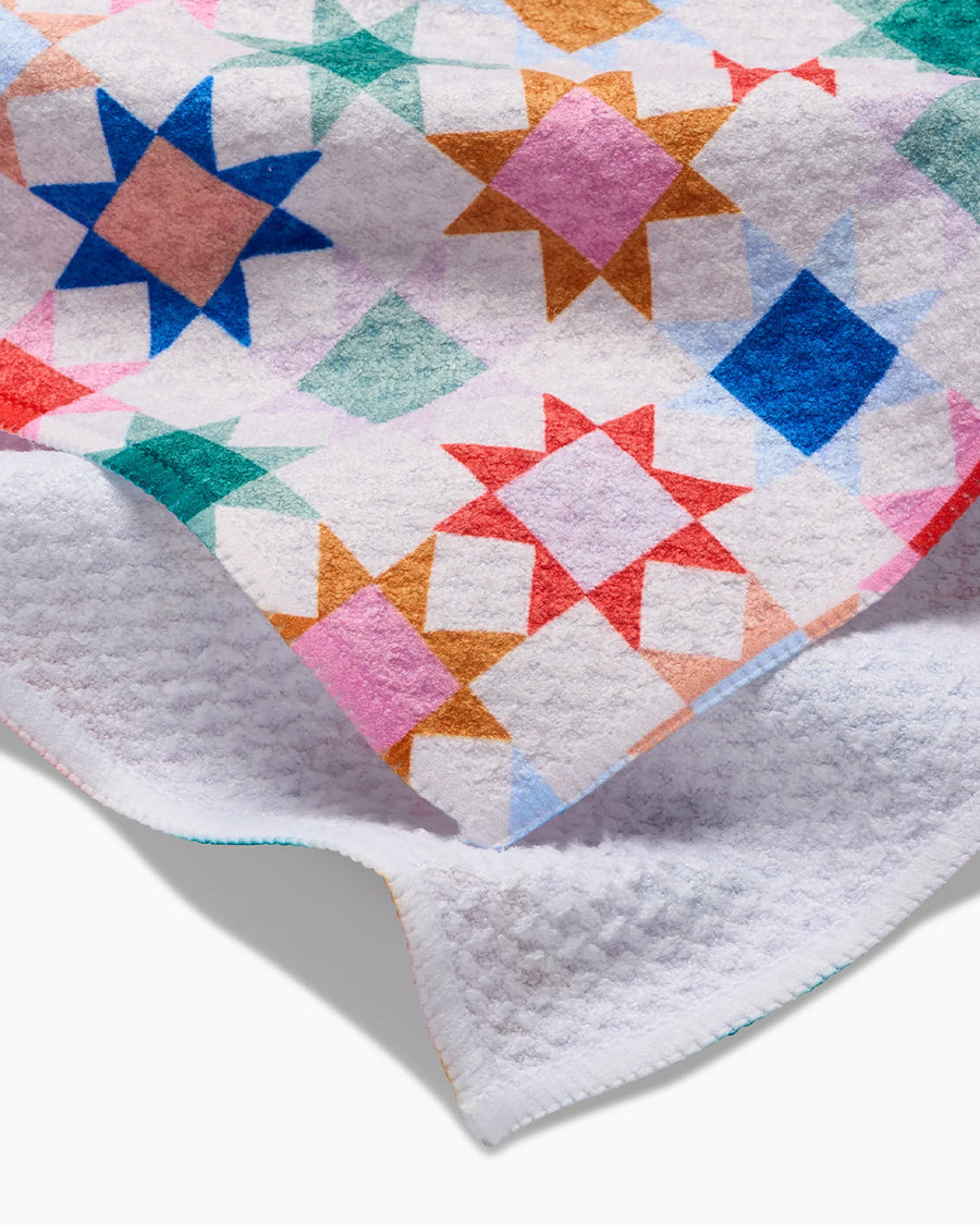 up close of white tea towel with colorful patchwork print