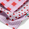 up close of set of three dish cloths: pink patchwork, tomato stripe, and tomato gingham