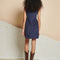 back view of model wearing blue corduroy mini dress with colorful button front