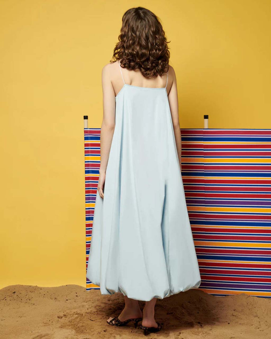 back view of model wearing light blue midi dress with spaghetti straps and bubble hem