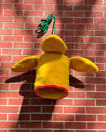 yellow daffodil pendant light on a brick background