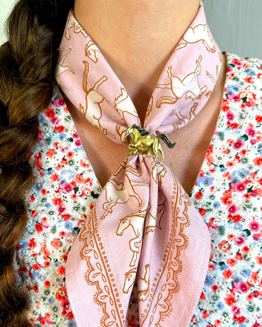 model wearing pink horse bandana with brass horse shaped bandana slide ring