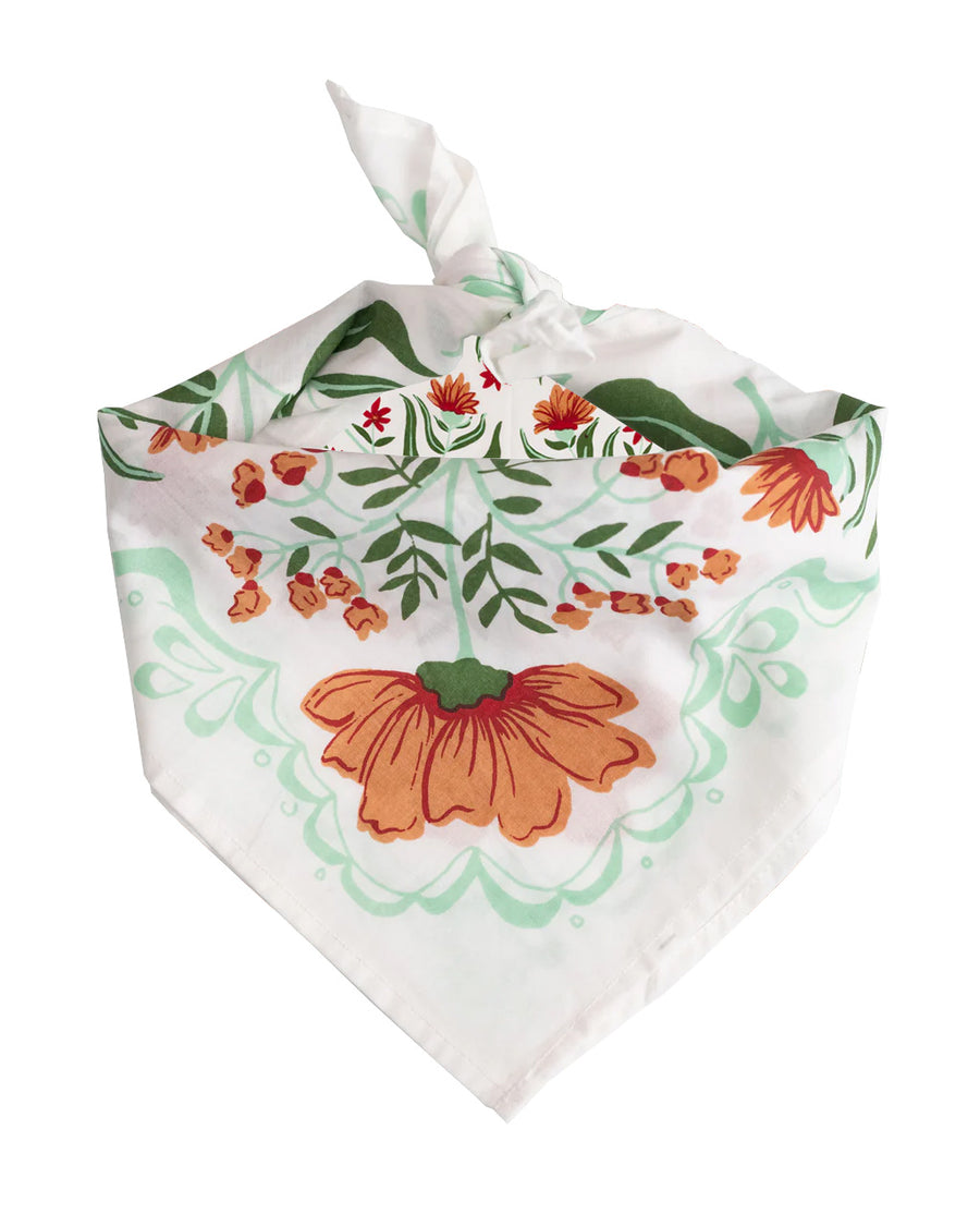 folded and tied white square bandana with rust colored flowers and green leaf print