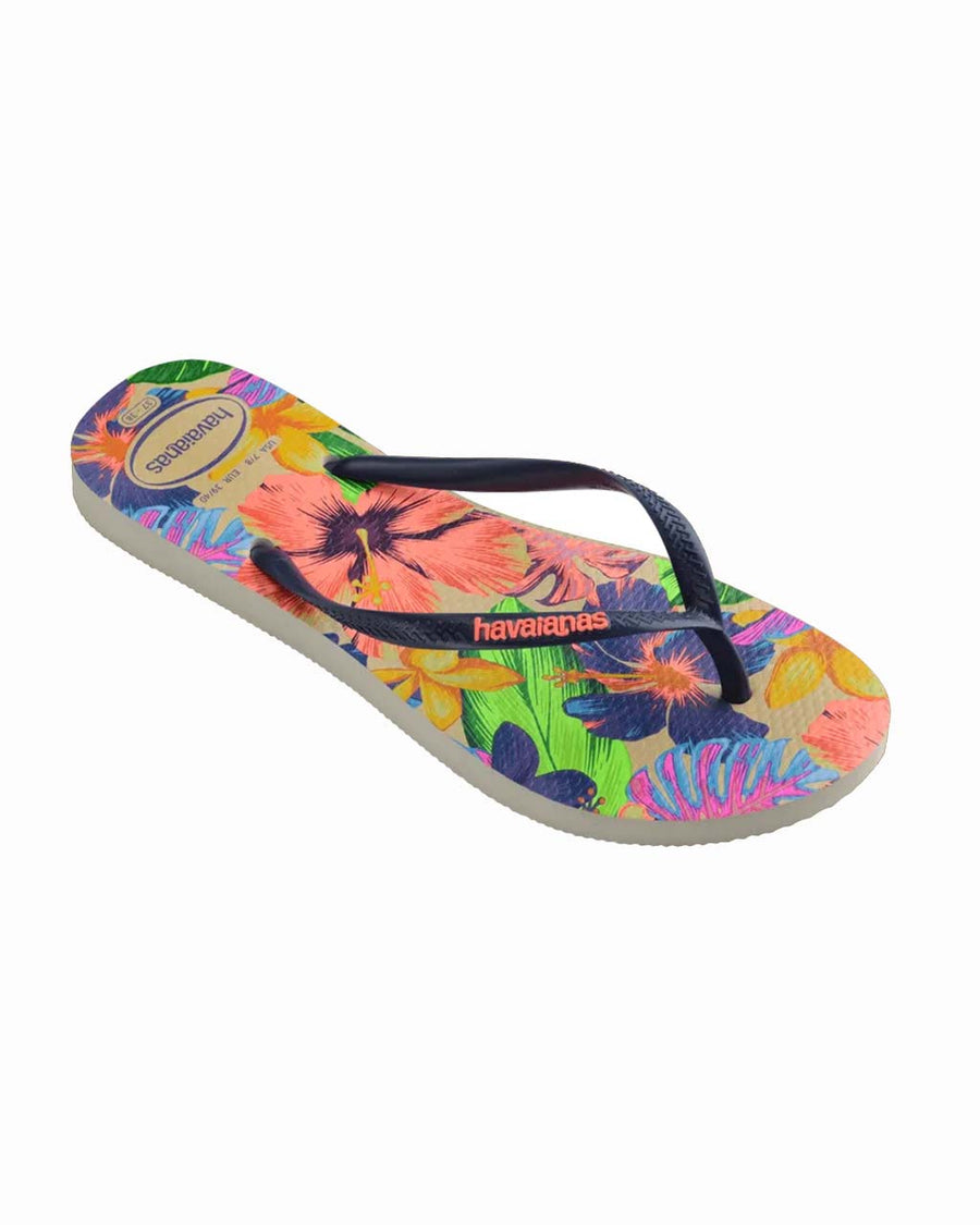 side view of pair of colorful neon floral print flip flops with navy thin straps