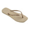 side view of tan square toed flip flops with metallic champagne thin straps