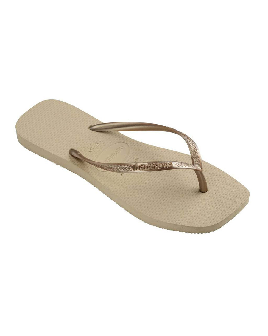 side view of tan square toed flip flops with metallic champagne thin straps