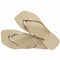 pair of tan square toed flip flops with metallic champagne thin straps