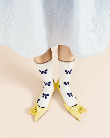 model wearing white crew socks with blue bow print