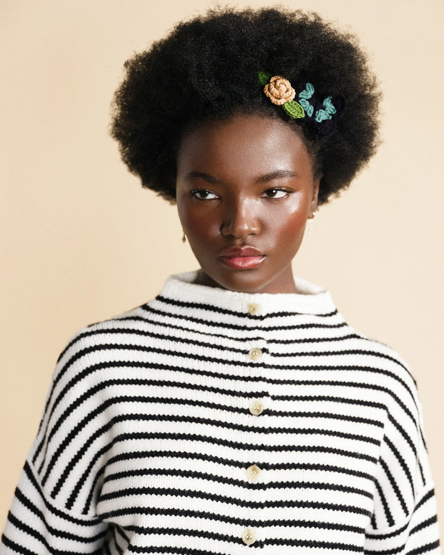 model wearing set of two hair clips: blue and black crochet butterfly and camel rosebud